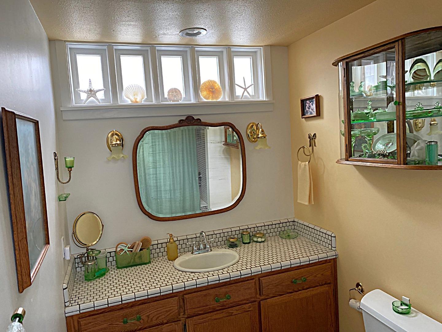 122 2nd Avenue Santa Cruz, CA 95062 - Photo 24 of 86 a bathroom with a granite countertop toilet a sink and a mirror