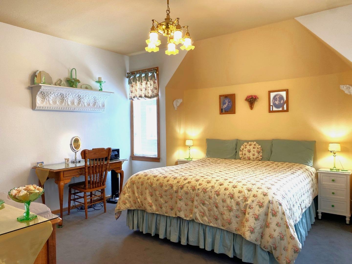 122 2nd Avenue Santa Cruz, CA 95062 - Photo 25 of 86 a bedroom with a bed table chair and a chandelier