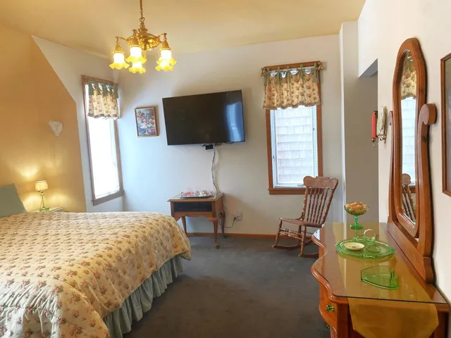 a bedroom with a bed tv and a window