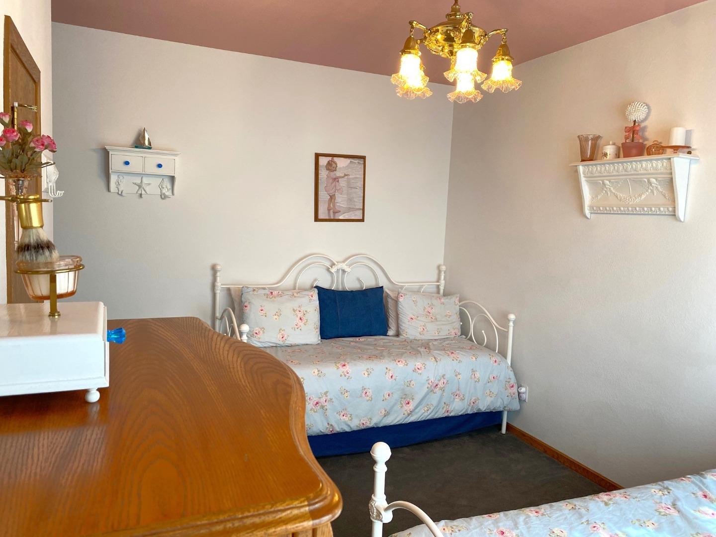 122 2nd Avenue Santa Cruz, CA 95062 - Photo 39 of 86 a bedroom with a bed and a chandelier