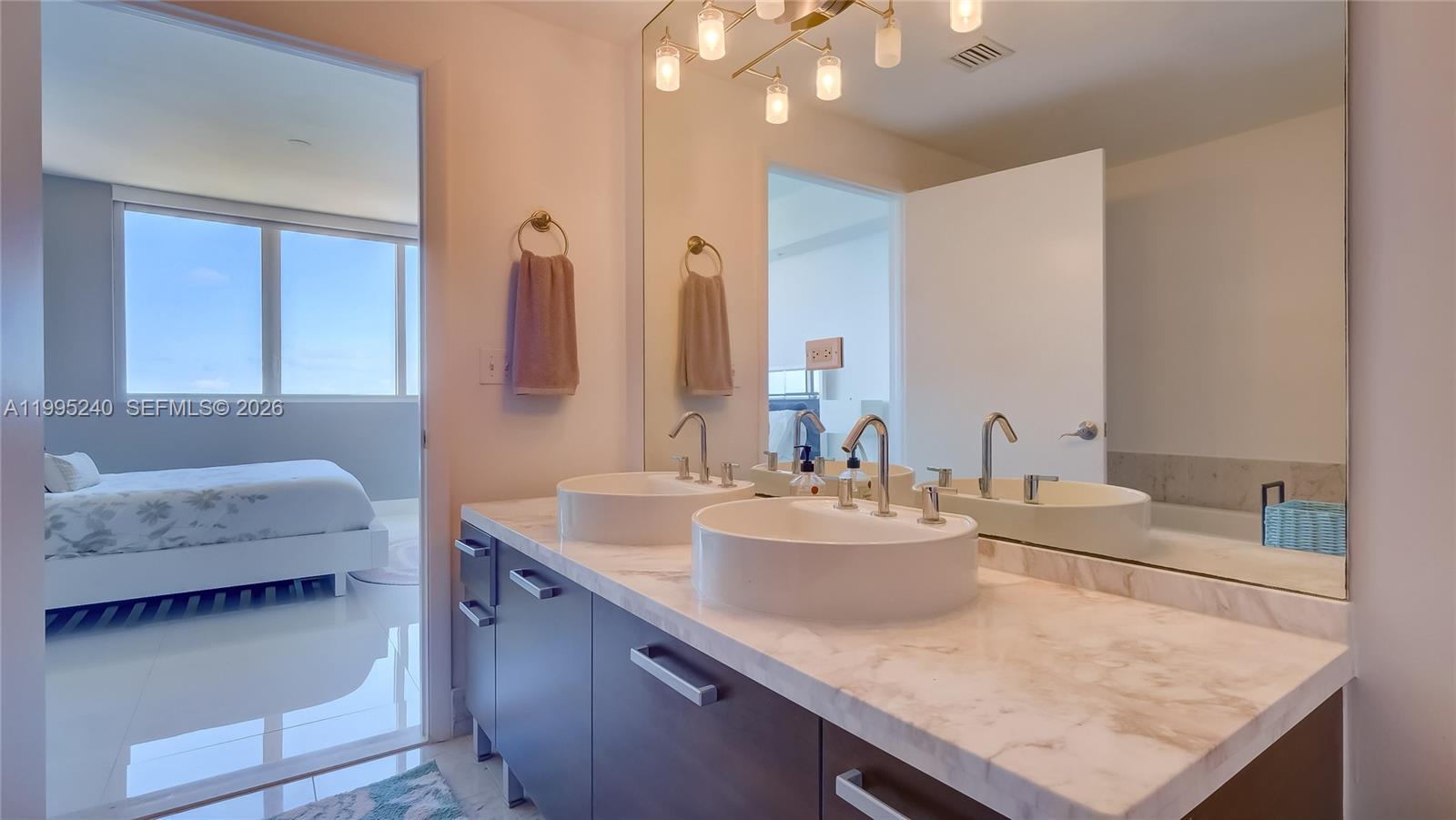 253 Northeast 2nd Street, Unit 3509 Miami, FL 33132 - Photo 26 of 49 a bathroom with a granite countertop sink and a mirror