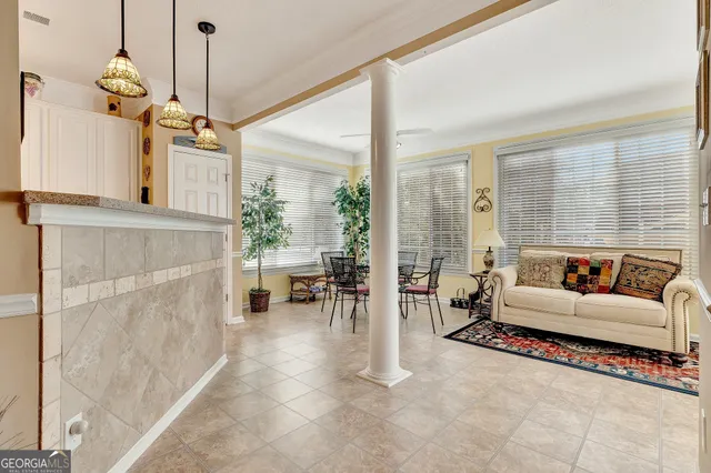 a living room with furniture a flat screen tv and a chandelier