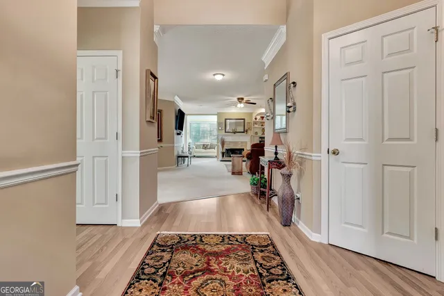 a view of a hallway view with living room and wooden floor