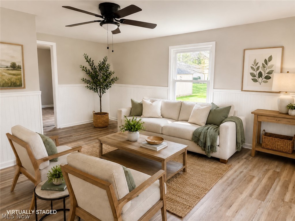 6666 Clingan Road Youngstown, OH 44514 - Photo 23 of 41 Living area featuring wood-finish flooring, white beadboard wainscoting, and neutral wall paint