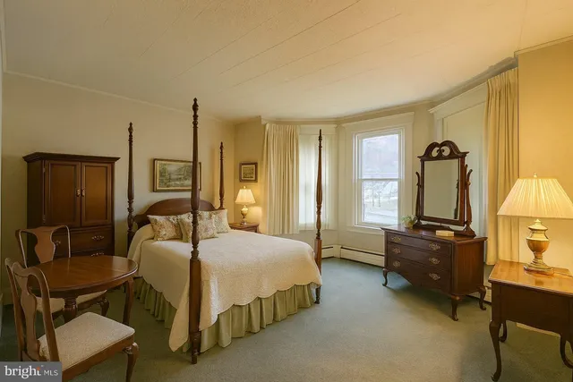 a bedroom with a bed a lamp and a dresser