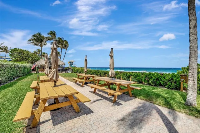 a view of a patio with dining table and chairs with wooden floor