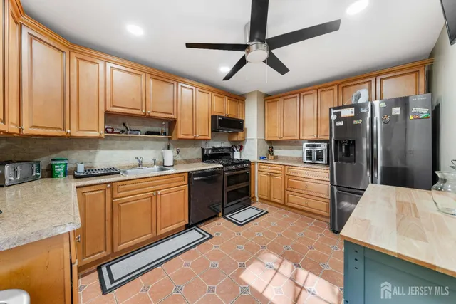a kitchen with stainless steel appliances granite countertop a refrigerator a stove top oven a sink and dishwasher