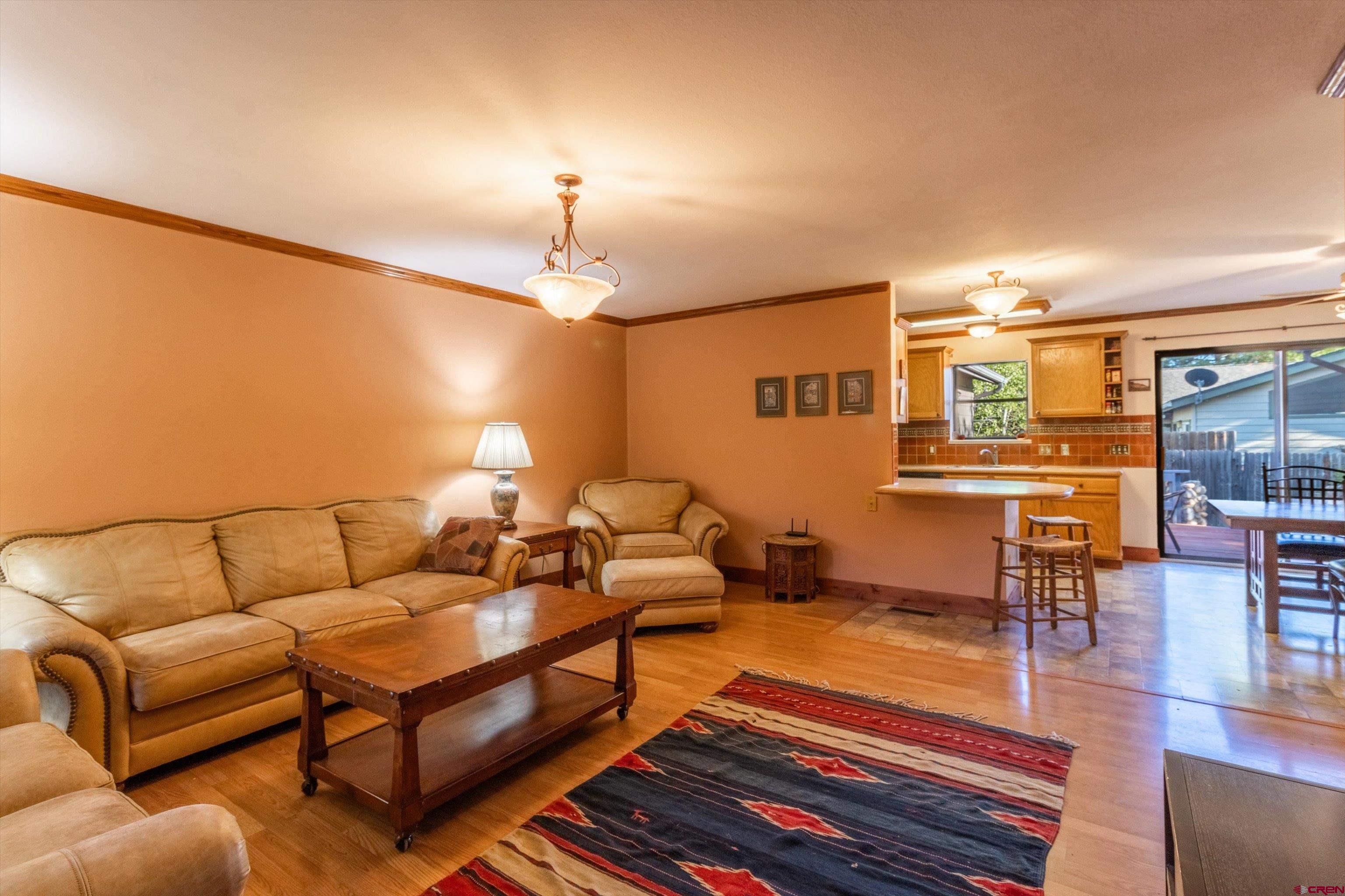 327 Hermosa Circle Durango, CO 81301 - Photo 19 of 32 a living room with furniture a lamp and a dining table with wooden floor