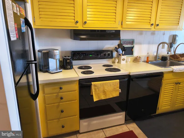 a kitchen with stainless steel appliances a sink a refrigerator and a counter top space