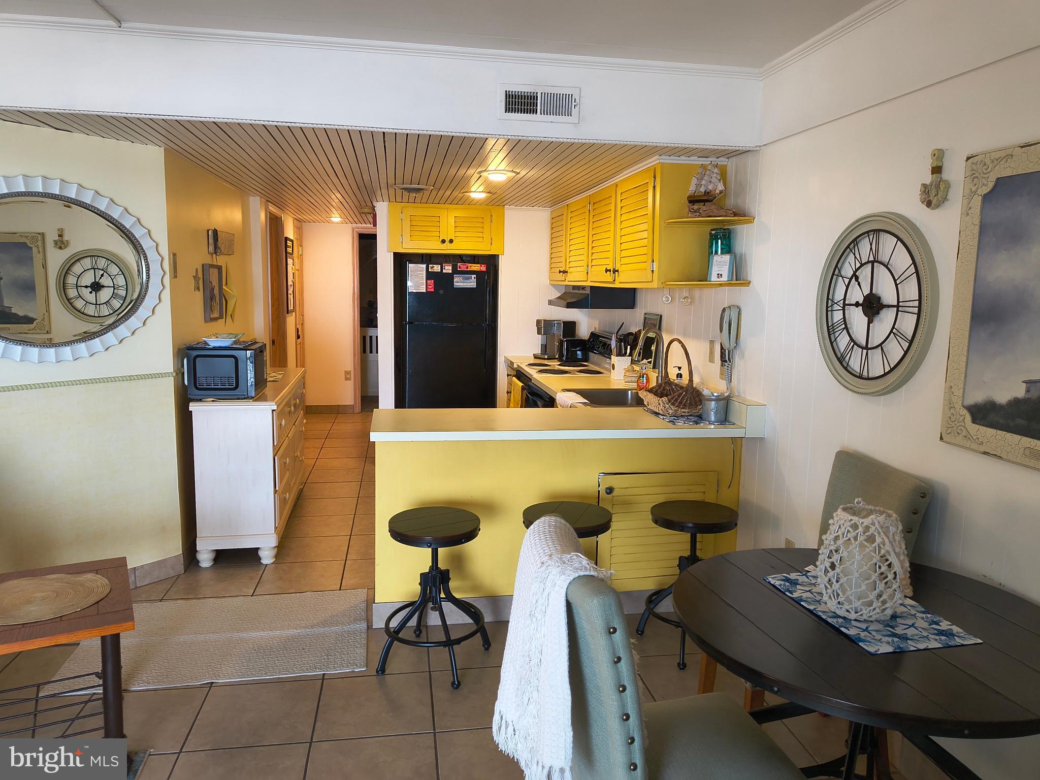 6803 Atlantic Avenue, Unit 4L Ocean City, MD 21842 - Photo 15 of 34 a dining room with furniture and a clock