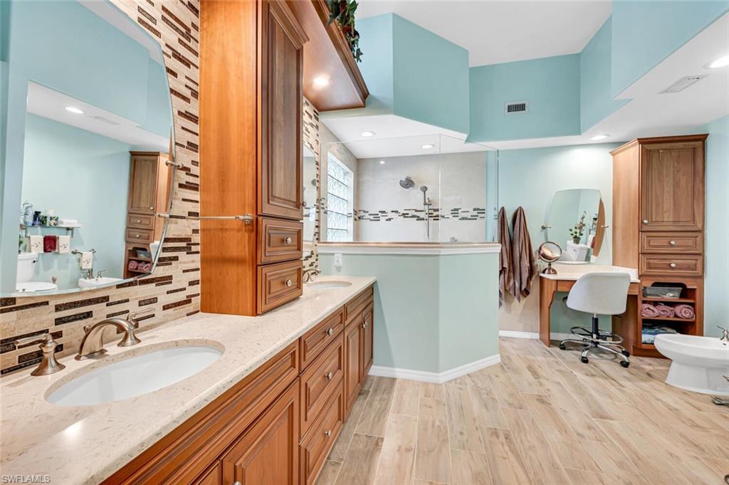 5735 Persimmon Way Naples, FL 34110 - Photo 12 of 49 Bathroom with wood-type flooring, a shower, backsplash, vanity, and a bidet