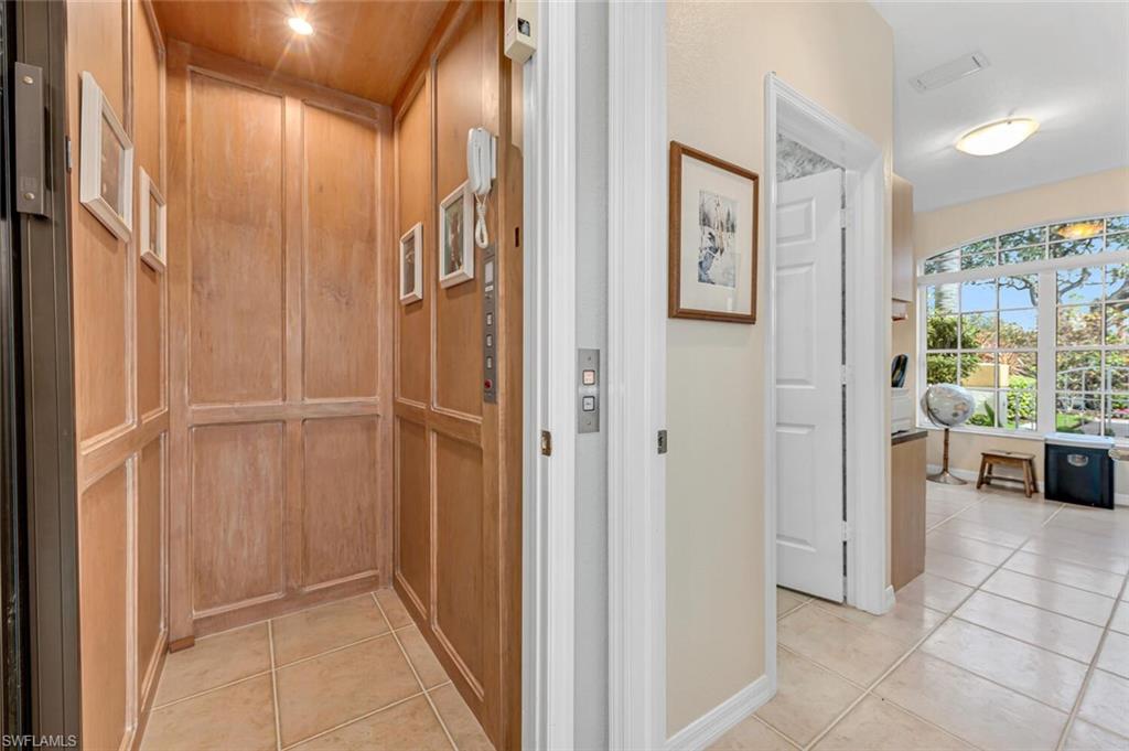 5735 Persimmon Way Naples, FL 34110 - Photo 13 of 49 Hallway with elevator and light tile patterned floors