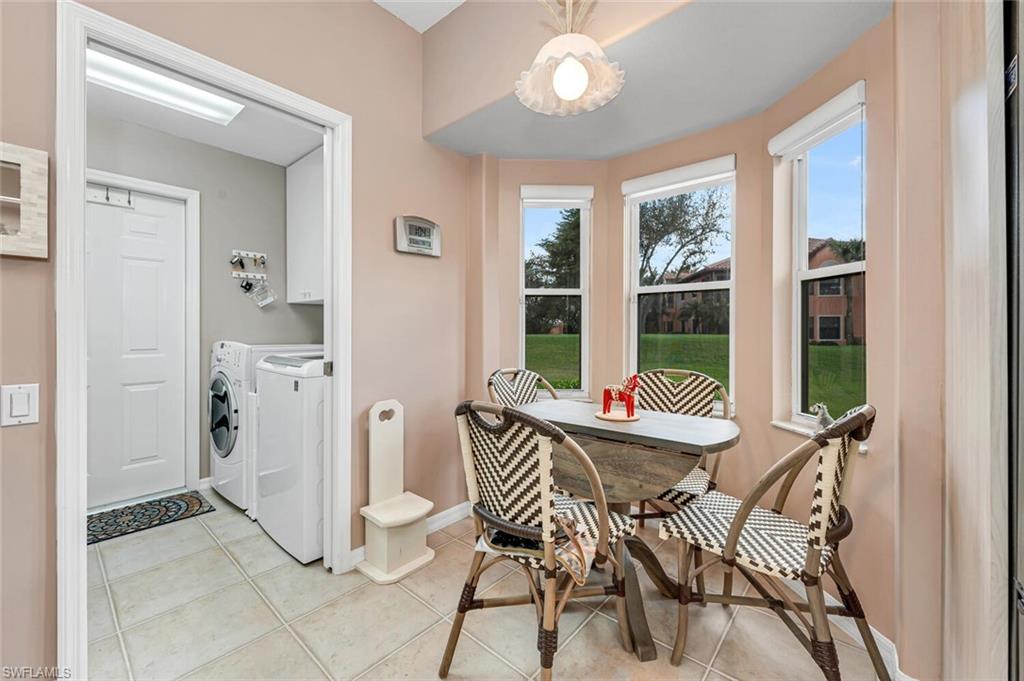 5735 Persimmon Way Naples, FL 34110 - Photo 7 of 49 Clothes washing area with light tile patterned floors, washer and clothes dryer, and cabinets