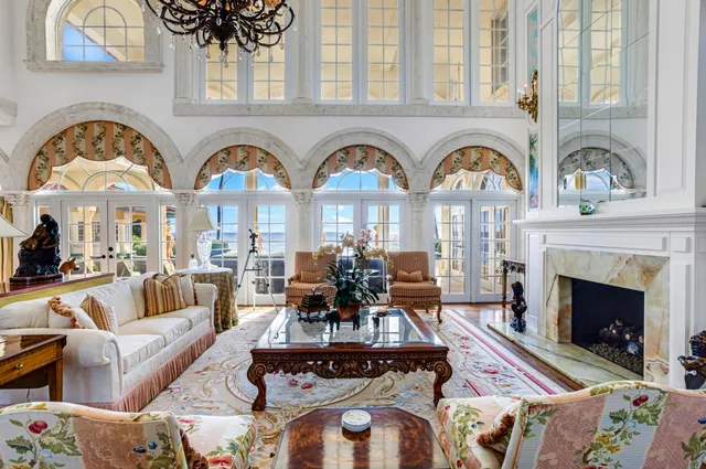 a living room with furniture a chandelier and a flat screen tv