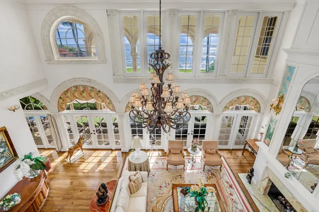 a living room with furniture a flat screen tv and a chandelier
