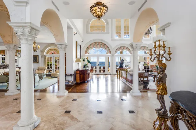 a living room with furniture a fireplace and a chandelier