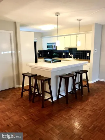 a kitchen with stainless steel appliances granite countertop a table chairs and a refrigerator