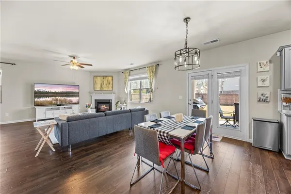 a view of a dining room and livingroom with furniture wooden floor a chandelier
