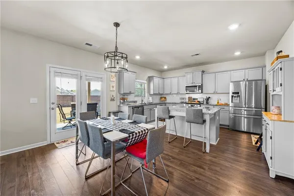 a view of a dining room and livingroom with furniture wooden floor a chandelier