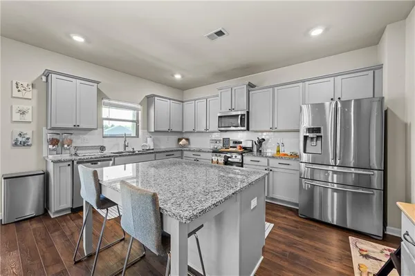 a kitchen with stainless steel appliances granite countertop a stove and cabinets