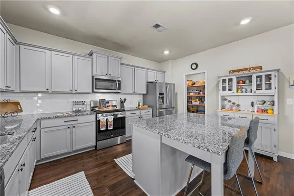 a kitchen with a counter top space a sink appliances and cabinets