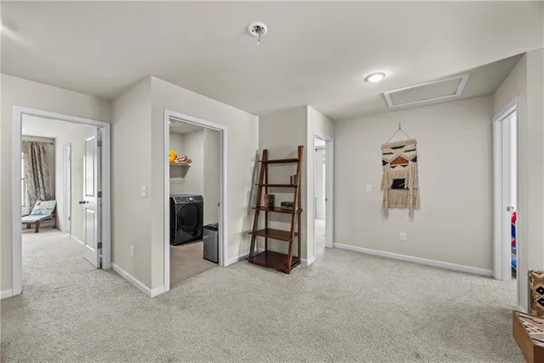 a spacious bedroom with a bed a couch and a chandelier