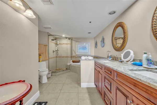 a spacious bathroom with a granite countertop toilet sink and mirror