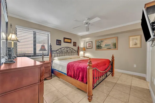 a bedroom with a large bed and a flat tv screen on dresser