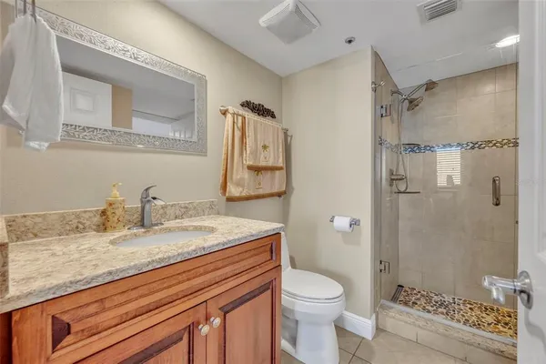 a bathroom with a granite countertop sink toilet and shower