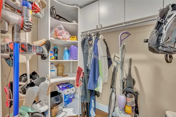 a view of walk in closet with clothes and shoes