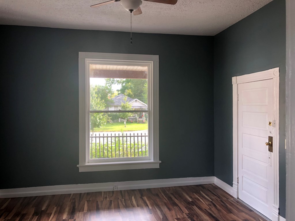 1345 18th Street Columbus, GA 31901 - Photo 8 of 16 a view of an empty room with wooden floor and a window