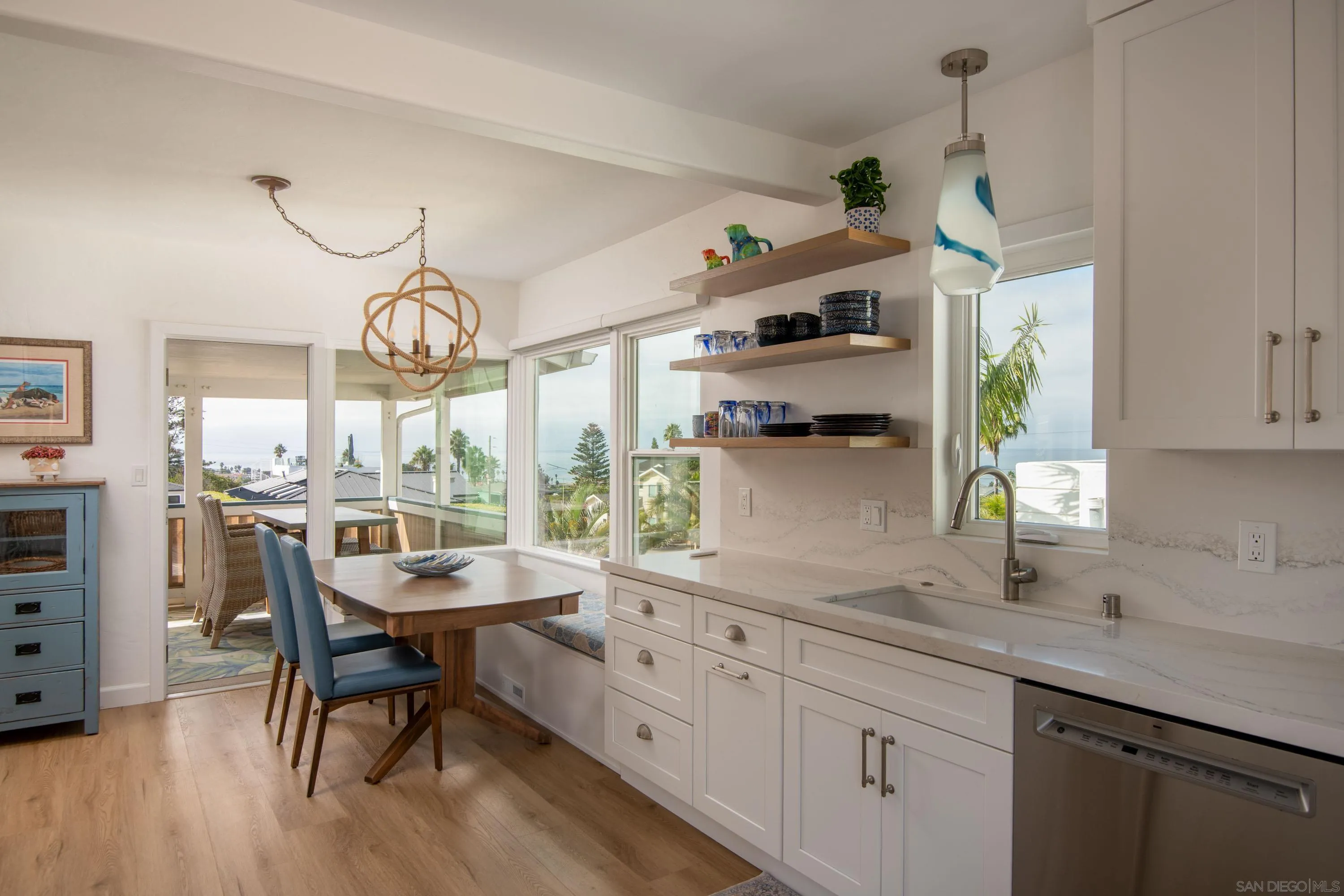 4484 Orchard Avenue San Diego, CA 92107 - Photo 12 of 36 a kitchen with stainless steel appliances kitchen island a large window and cabinets