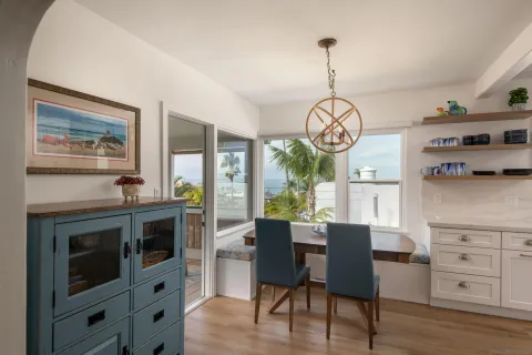 a view of a dining room with furniture a kitchen and chandelier