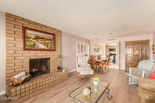 a living room with a fireplace furniture a rug and a window