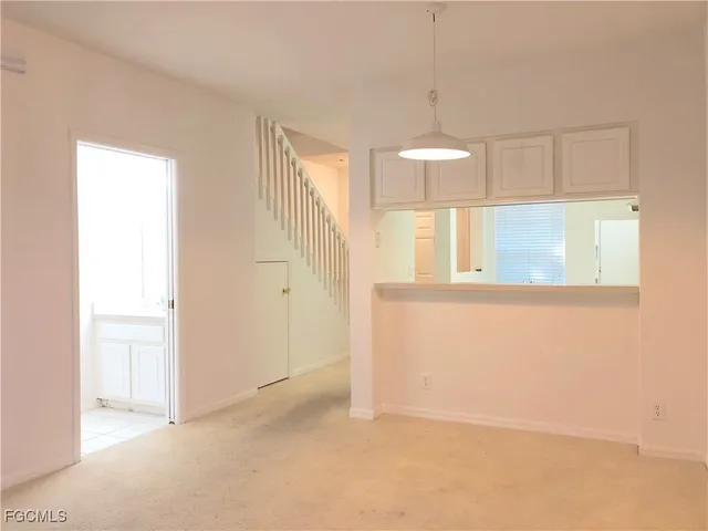 an empty room with windows and chandelier fan