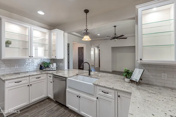 a kitchen with stainless steel appliances kitchen island granite countertop a refrigerator and a sink