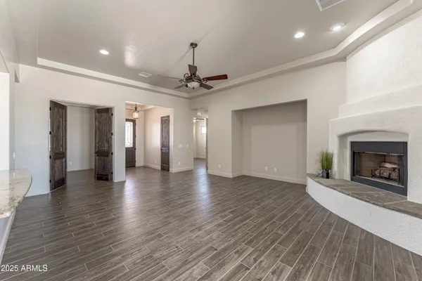 a view of a hallway with wooden floor and a living room