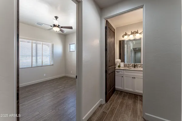 a view of empty room with wooden floor and fan