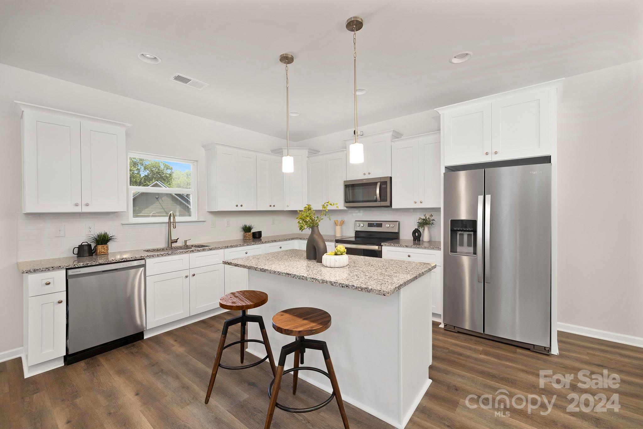 310 Morningside Road Charlotte, NC 28214 - Photo 6 of 23 a kitchen with stainless steel appliances granite countertop a refrigerator a sink dishwasher a stove and white cabinets with wooden floor