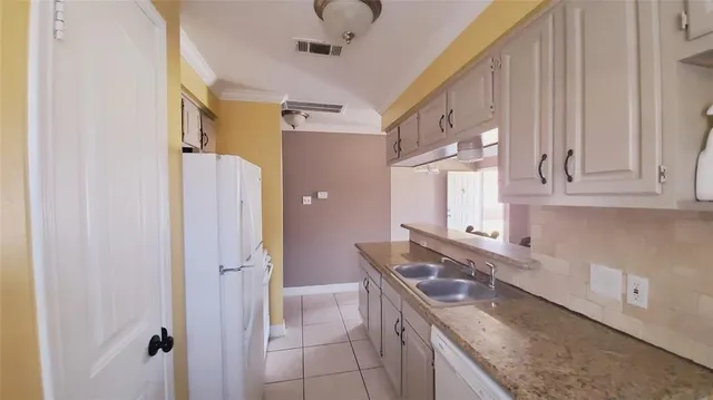 a kitchen with stainless steel appliances granite countertop a sink and a refrigerator