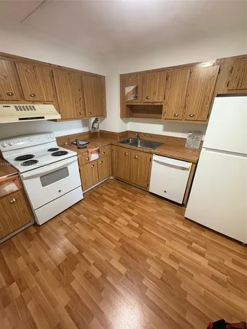 a kitchen with a stove a sink and a refrigerator