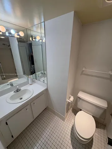 a bathroom with a granite countertop toilet sink and mirror