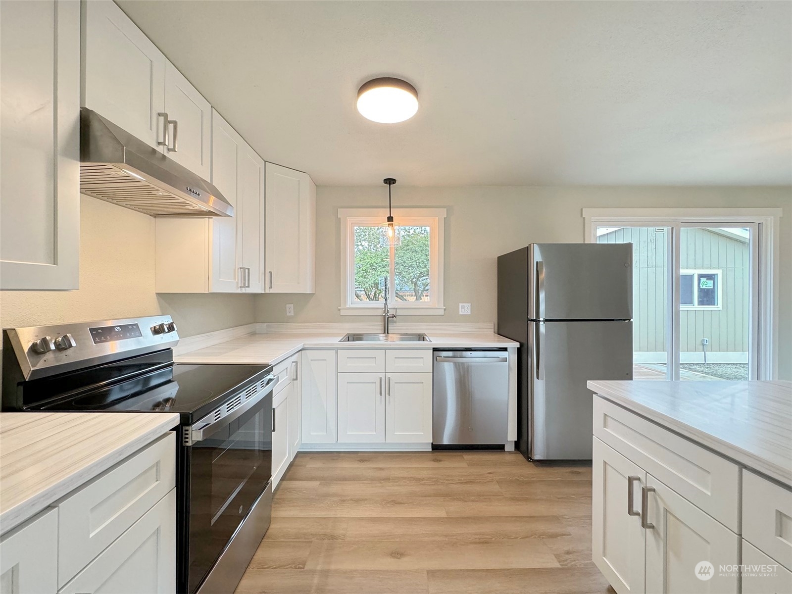 218 North Matriotti Avenue Sequim, WA 98382 - Photo 11 of 40 a kitchen with a refrigerator and a stove top oven