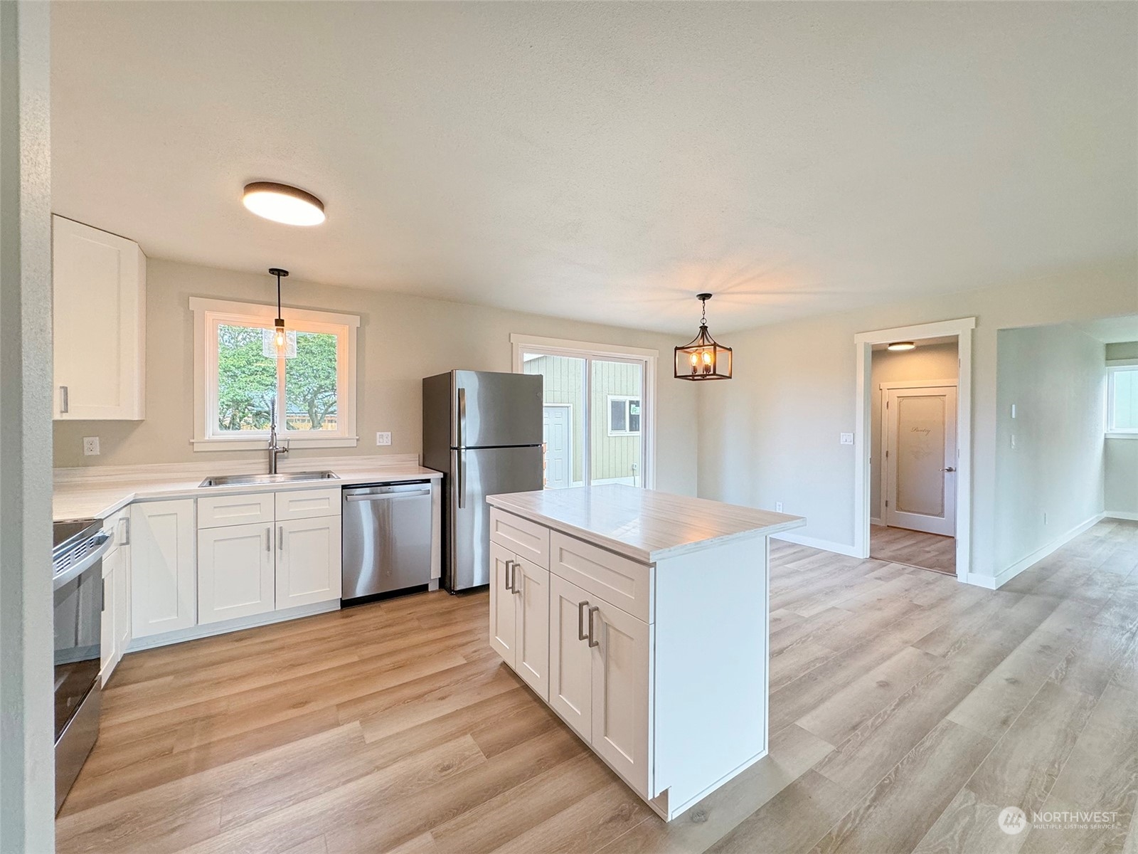 218 North Matriotti Avenue Sequim, WA 98382 - Photo 12 of 40 a kitchen with a white cabinets and wooden floor
