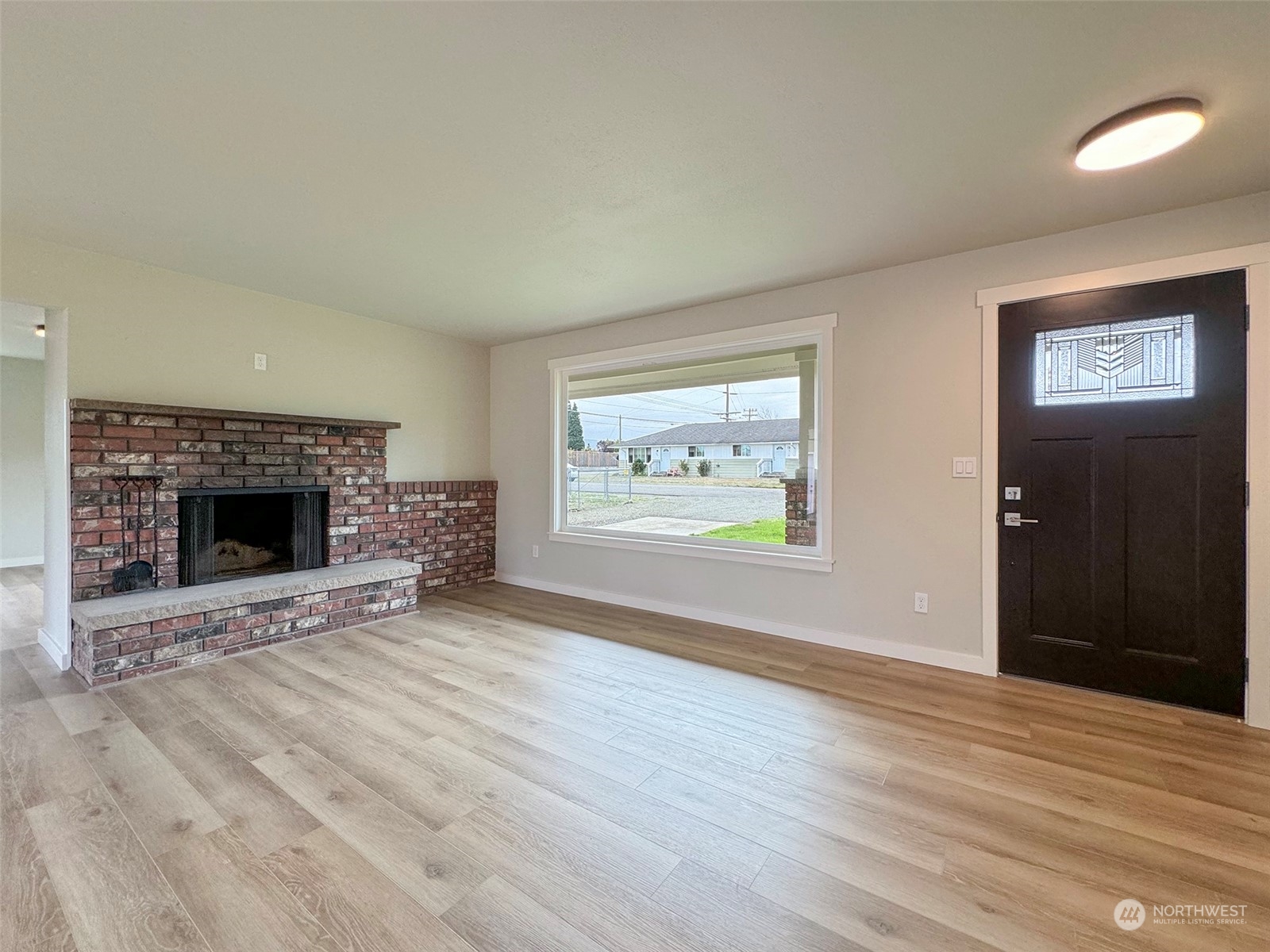 218 North Matriotti Avenue Sequim, WA 98382 - Photo 4 of 40 an empty room with wooden floor fireplace and window