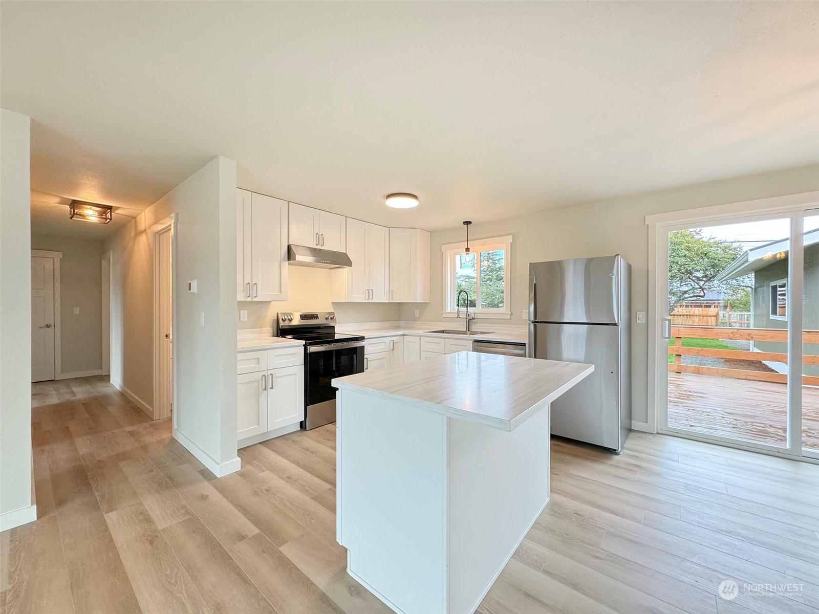 218 North Matriotti Avenue Sequim, WA 98382 - Photo 7 of 40 a large kitchen with stainless steel appliances kitchen island granite countertop a refrigerator and a stove top oven