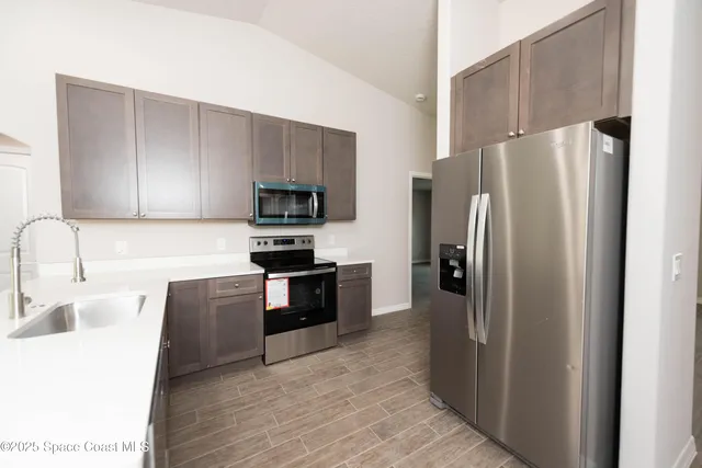 a kitchen with stainless steel appliances granite countertop a refrigerator stove a sink and dishwasher