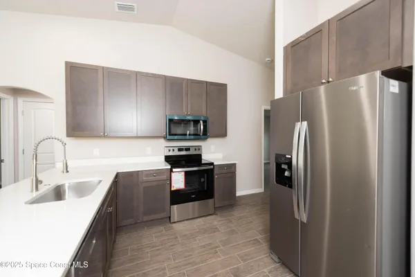 a kitchen with stainless steel appliances a refrigerator sink and stove