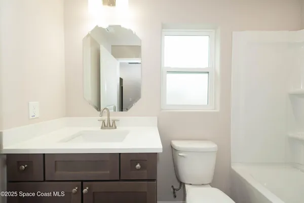 a bathroom with a sink toilet and mirror