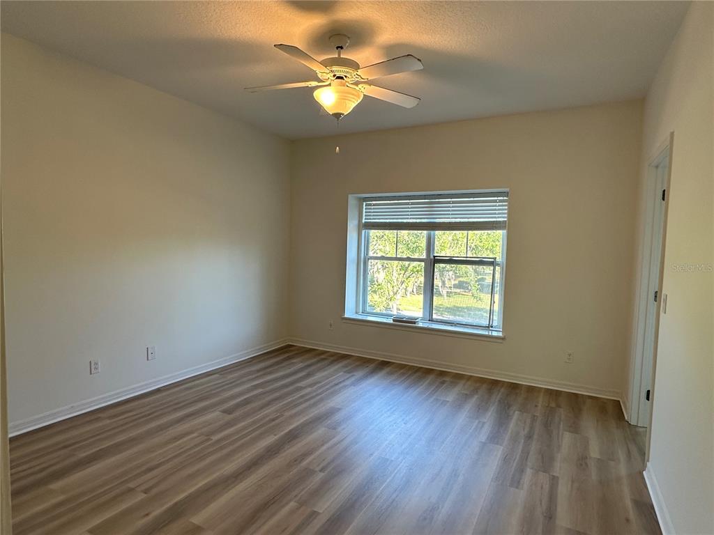 7668 Billingham Street Windermere, FL 34786 - Photo 6 of 15 a view of an empty room with a window and wooden floor